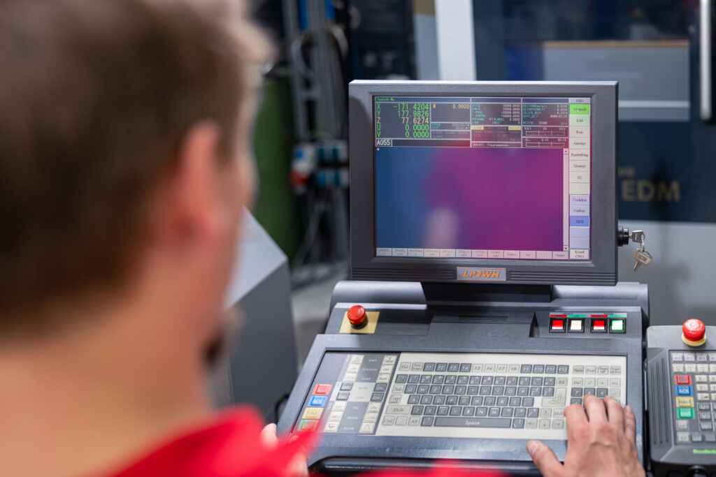Ein Mitarbeiter bedient eine CNC-Maschine für den Spritzguss im Werkzeugbau bei Schröder und Heidler.