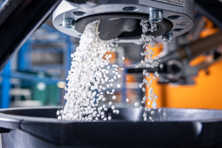 Kunststoffgranulate fallen präzise aus einer Spritzgussmaschine in einen Behälter bei Schröder und Heidler.